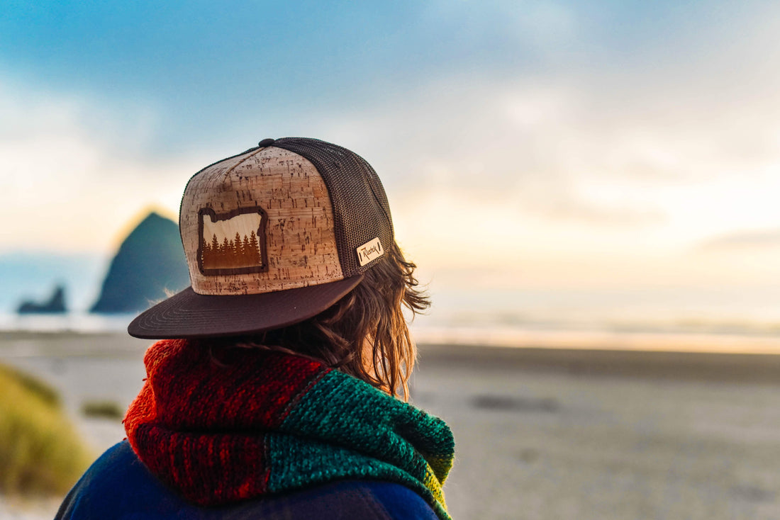 A person watching the sun set over the ocean wearing a Rustek Cork Hat